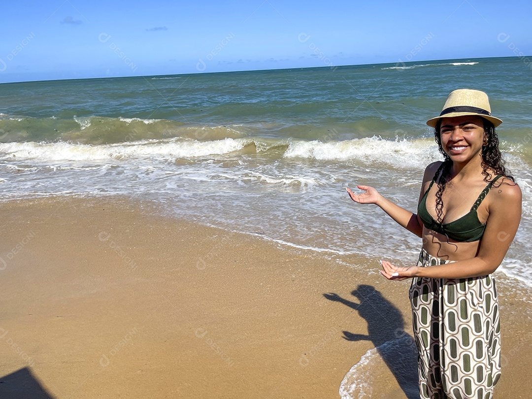 Jovem feliz usando chapéu na praia