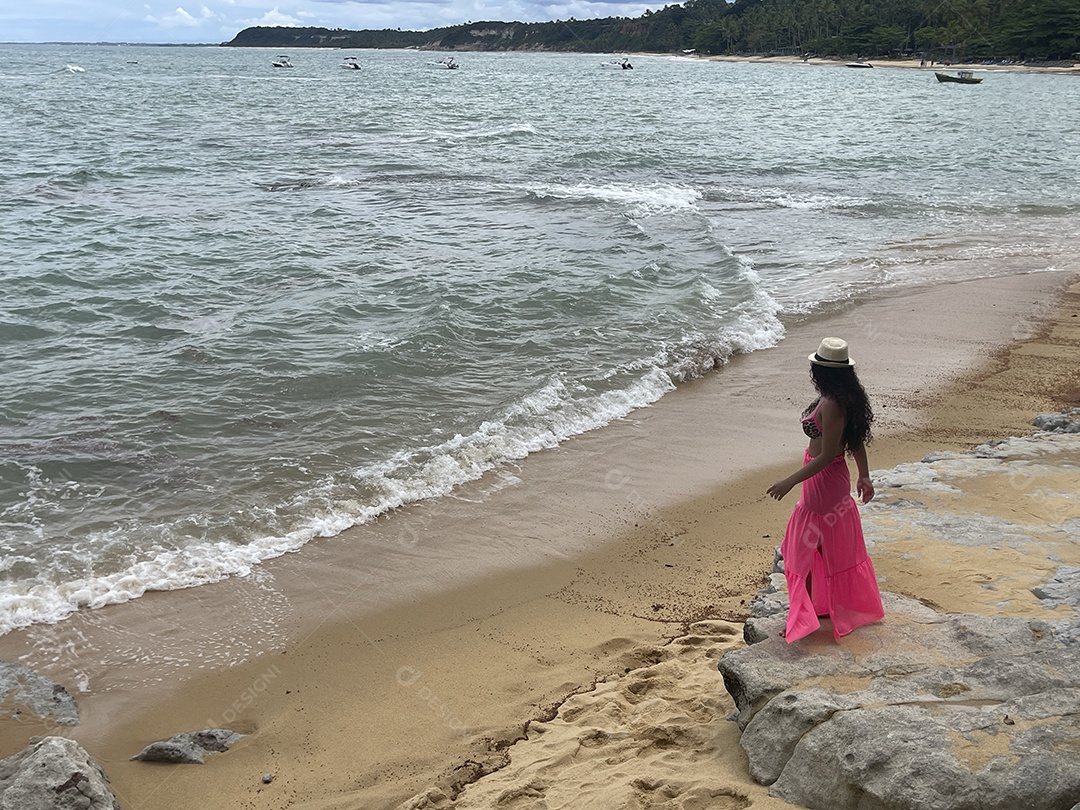 Jovem linda olhando ondas no mar