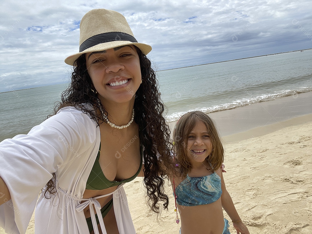 Mãe e filha see divertindo na praia