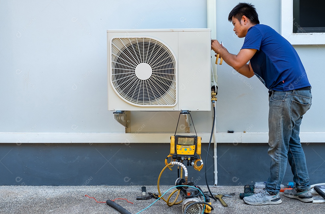Homem dando manutenção em ar condicionado