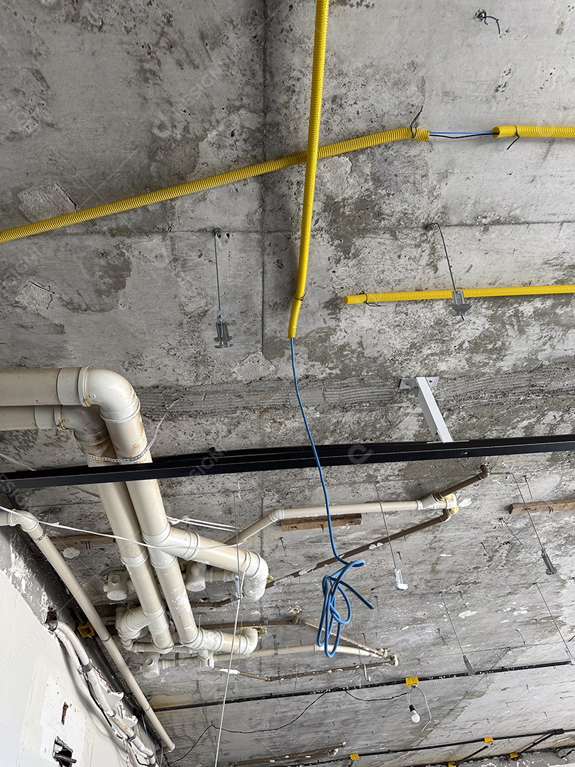 Instalação de teto com tubos e conduítes em canteiro de obras