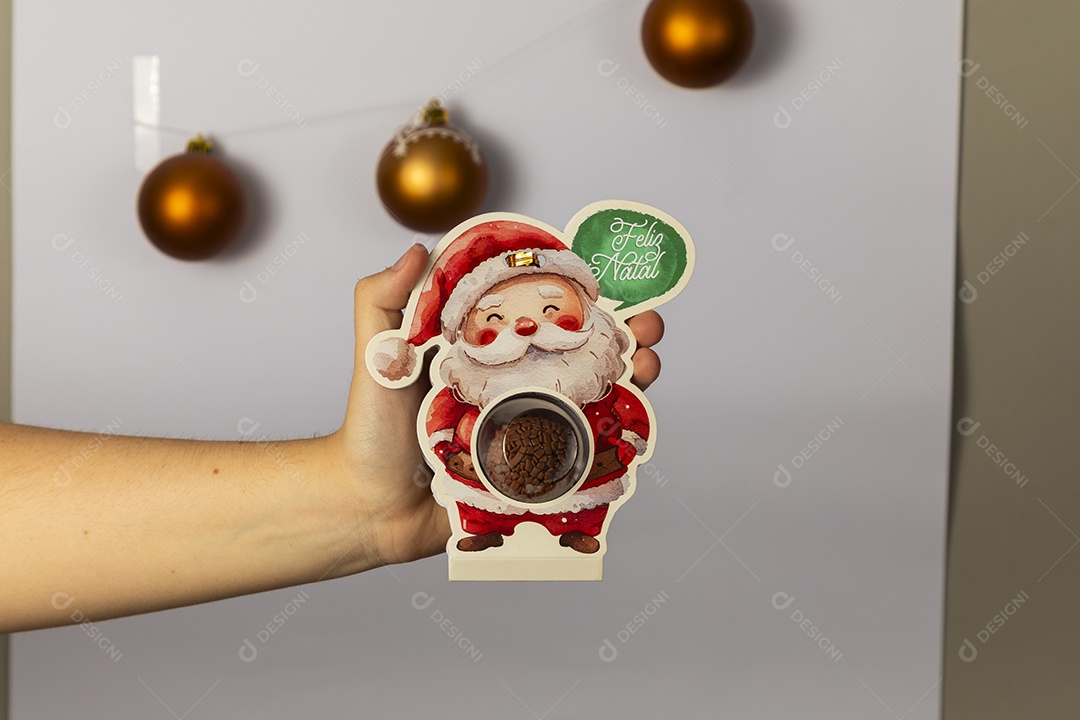 Mão segurando lembrança de papai noel para o natal