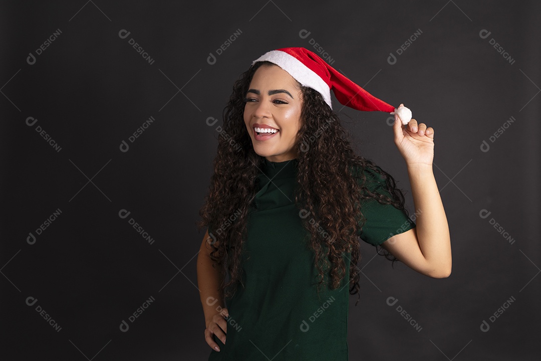 Linda mulher feliz com mãos no gorro vermelho