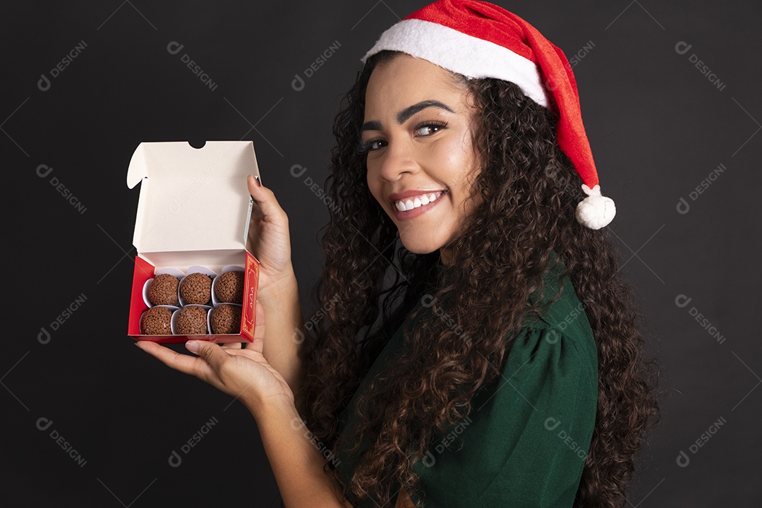 Mulher com caixa de brigadeiro com gorro na cabeça