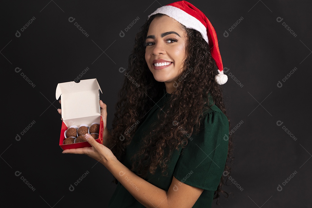 Mulher com caixa de brigadeiro com gorro na cabeça