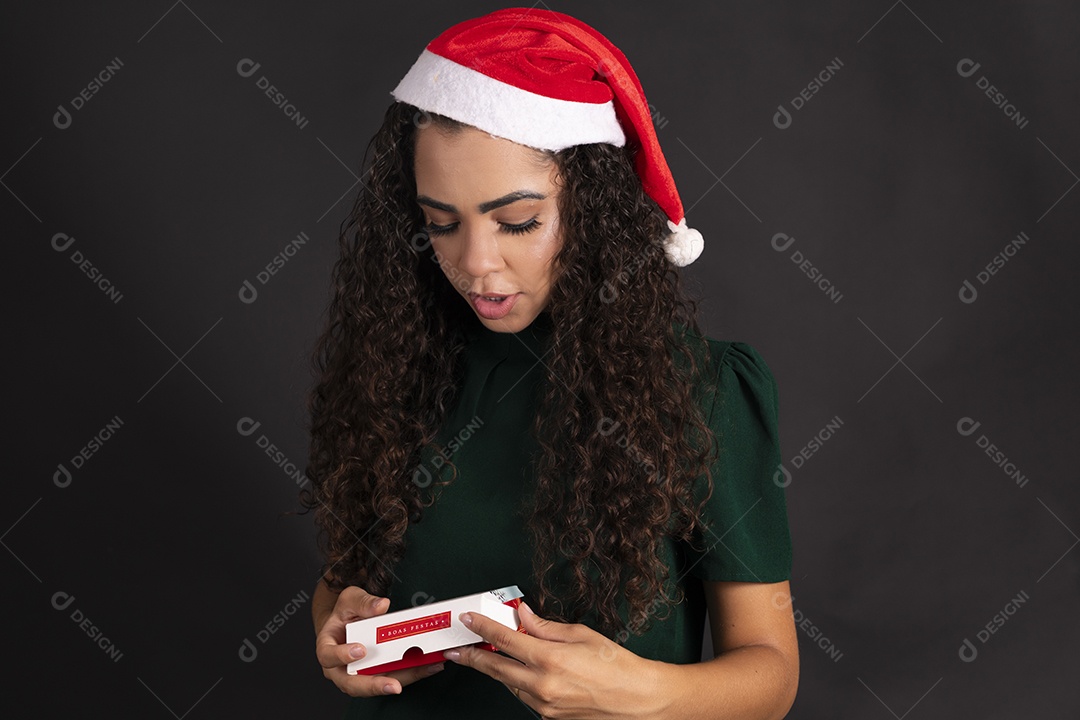 Linda mulher com gorro vermelho na cabeça e segurando caixa de bombom