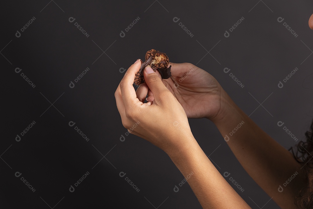 Mão segurando brigadeiro recheado