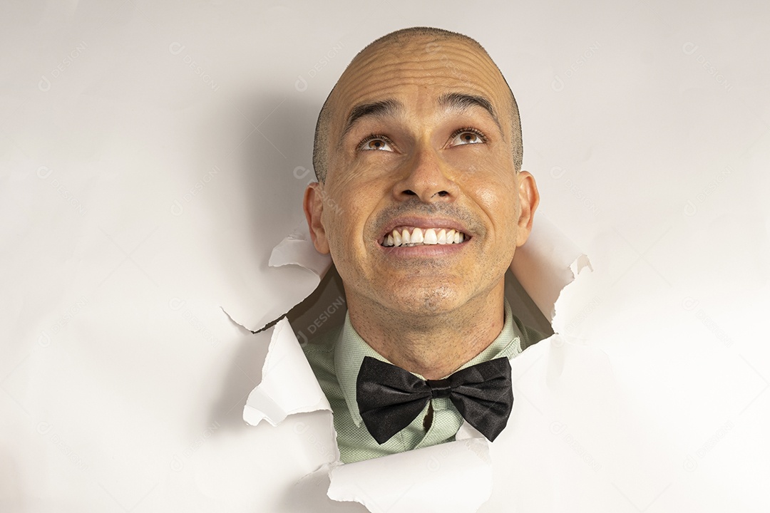 Homem fazendo careta com cabeça atráves do buraco rasgado