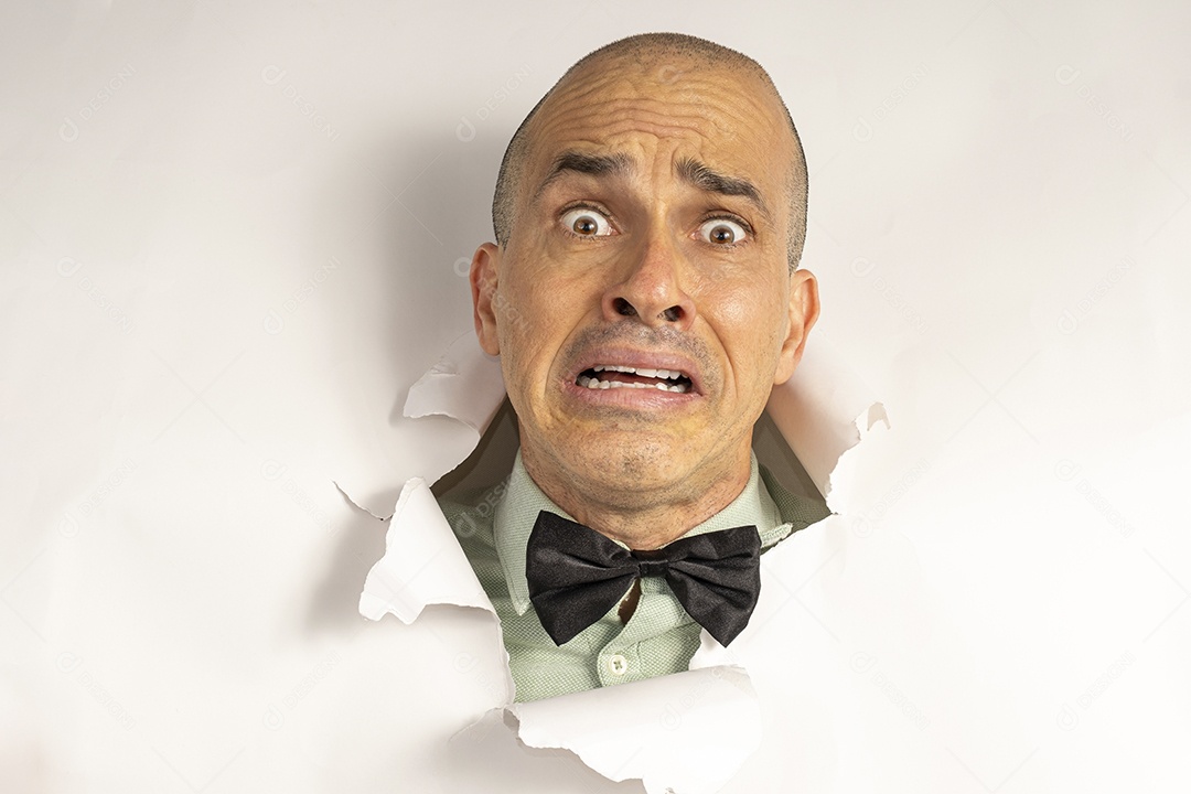 Homem fazendo careta com cabeça atráves do buraco rasgado