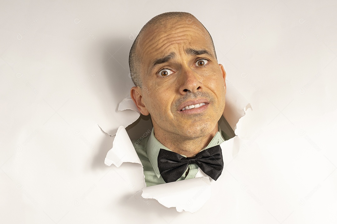 Homem com gravata e cabeça no buraco fazendo careta