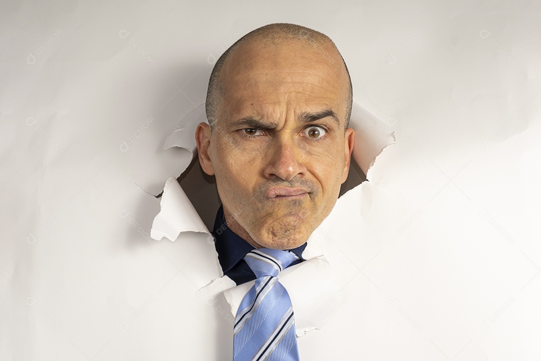 Homem fazendo caretas atráves de um buraco no papel