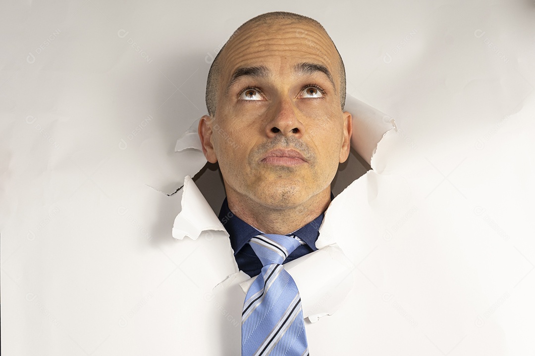 Homem com cabeça atráves de buraco olhando para cima