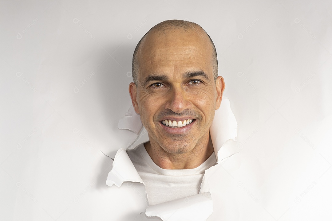 Homem com cabeça atráves de buraco no papel sorrindo