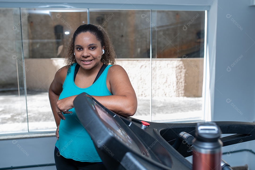 Mulher desportiva exercitando em multiestação na academia