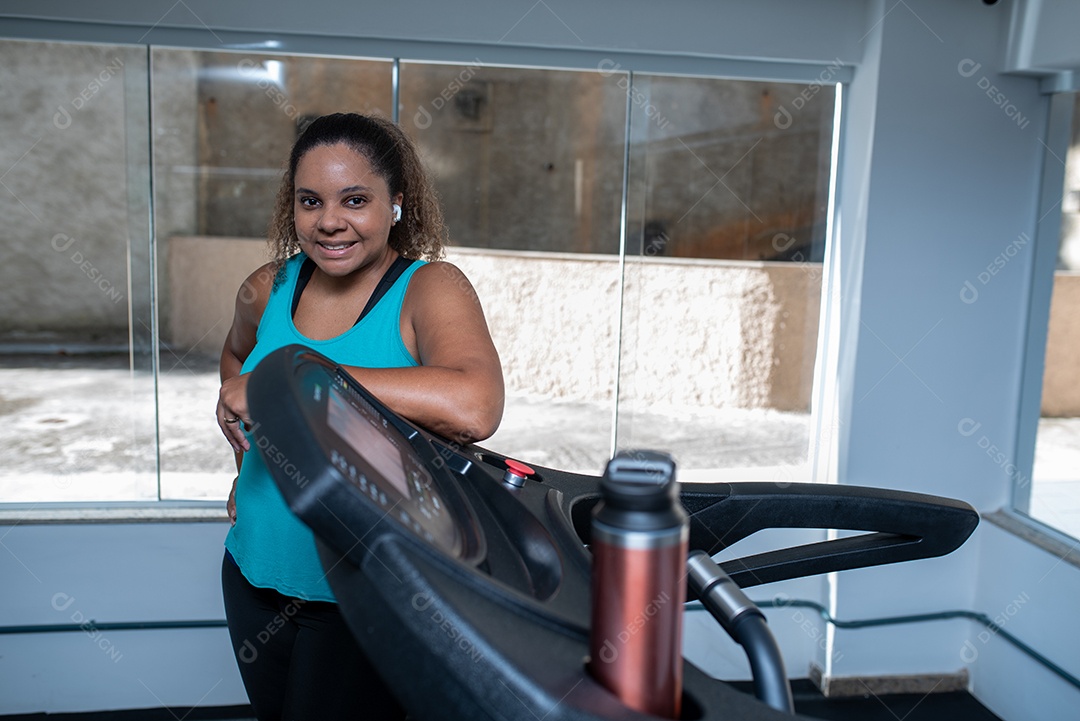 Mulher desportiva exercitando em multiestação na academia