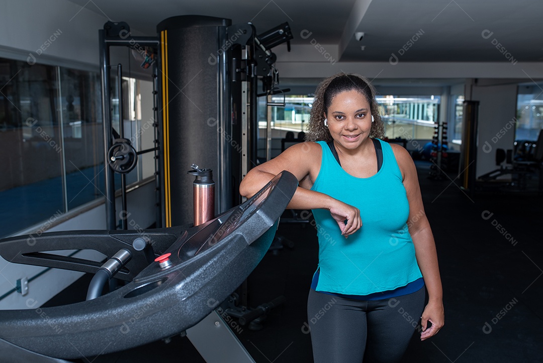 Mulher desportiva exercitando em multiestação na academia