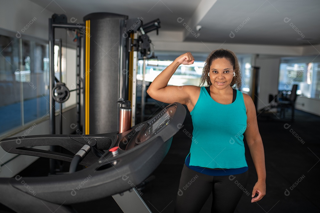 Mulher desportiva exercitando em multiestação na academia