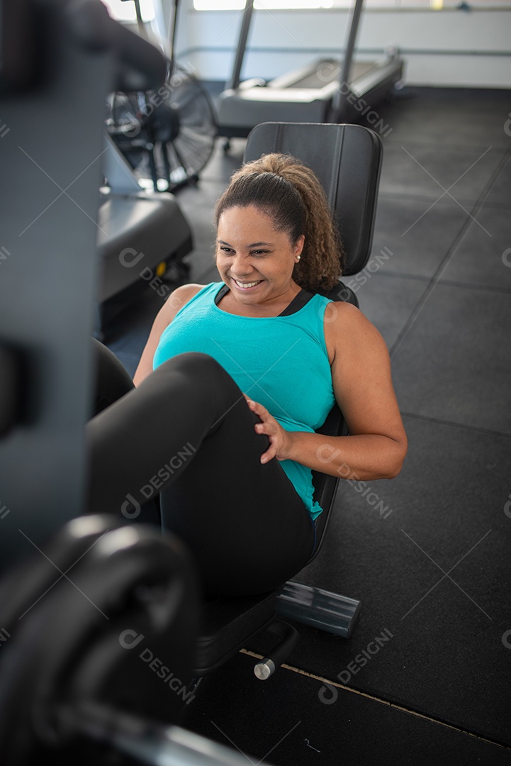 Mulher desportiva exercitando em multiestação na academia