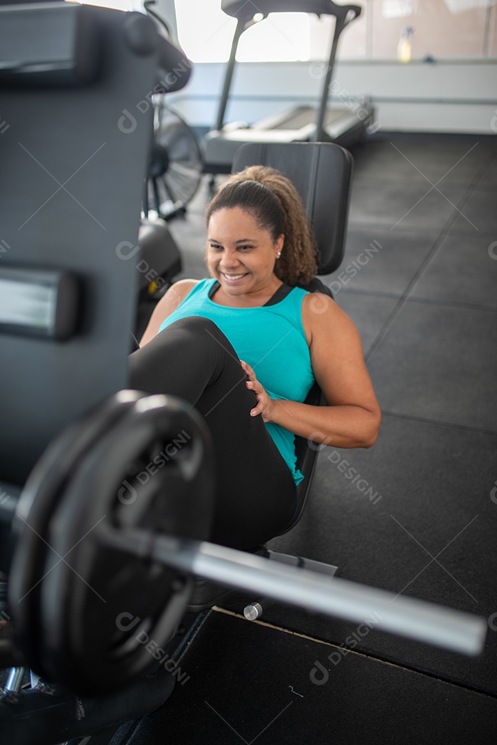 Mulher desportiva exercitando em multiestação na academia