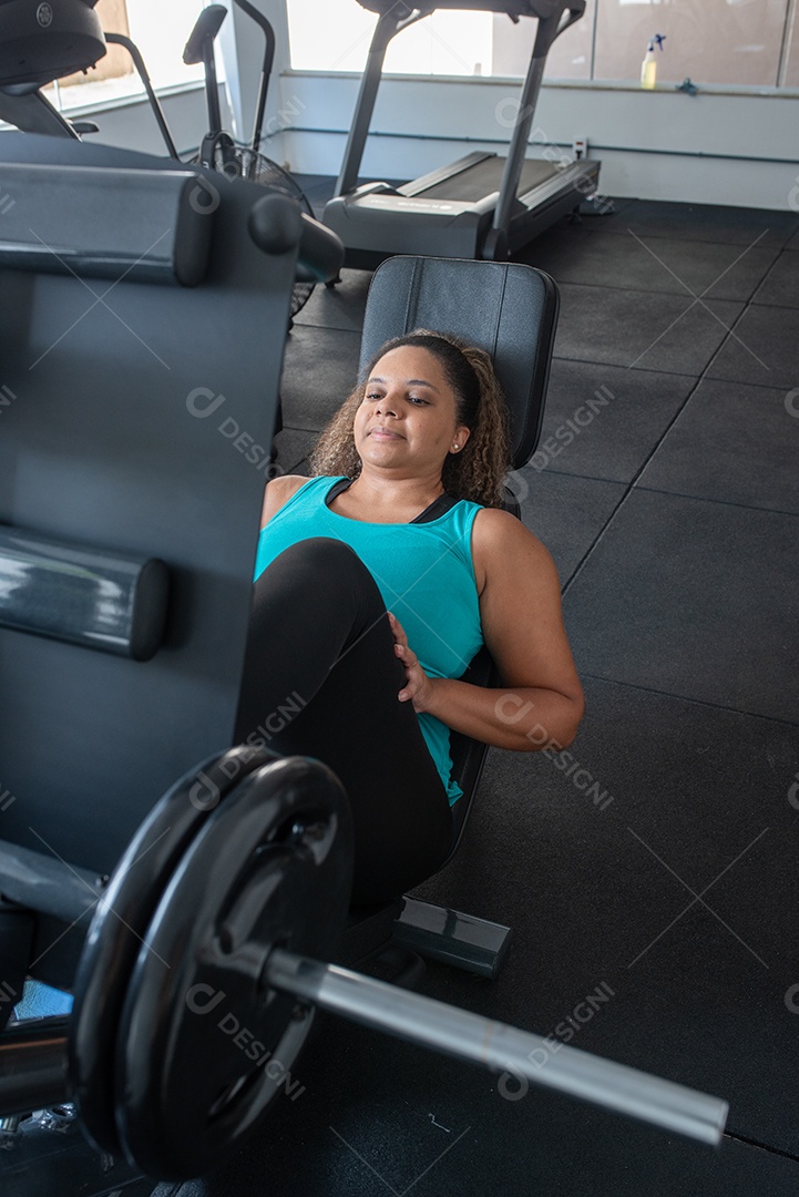Mulher desportiva exercitando em multiestação na academia