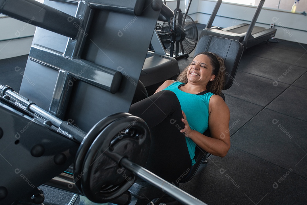 Mulher desportiva exercitando em multiestação na academia