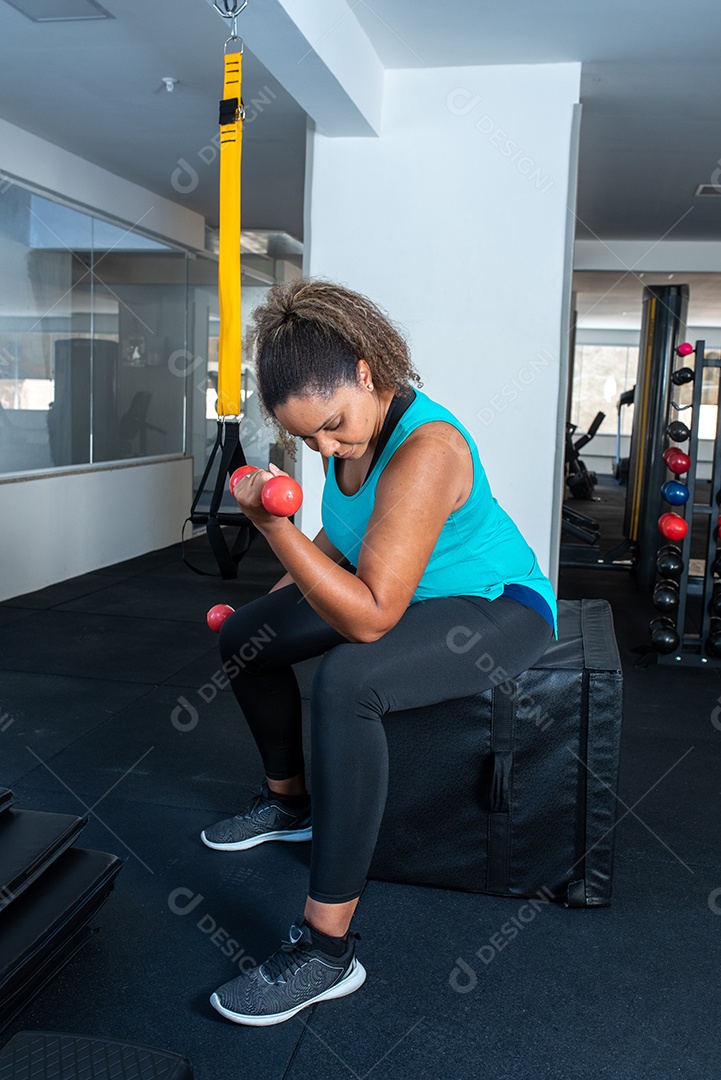 Mulher desportiva exercitando em multiestação na academia