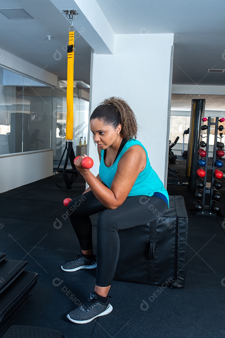 Mulher desportiva exercitando em multiestação na academia