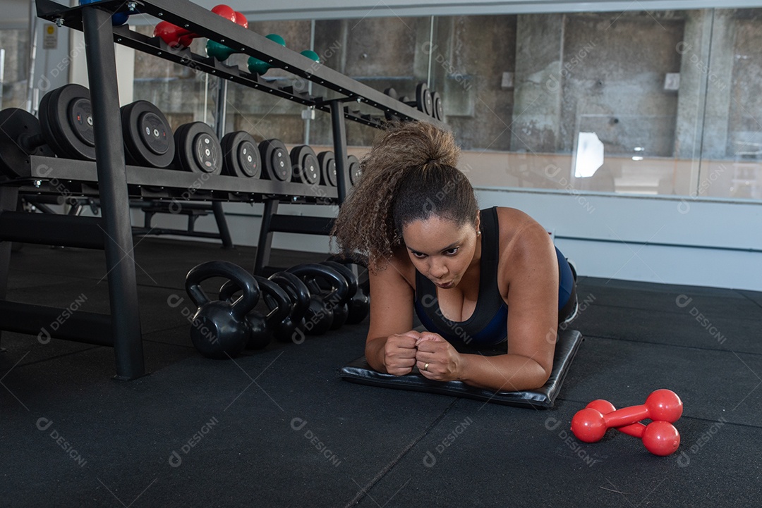 Mulher desportiva exercitando em multiestação na academia