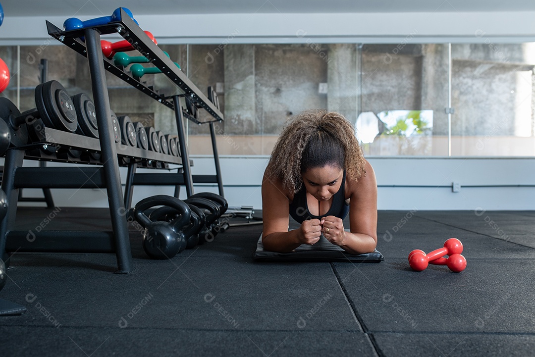 Mulher desportiva exercitando em multiestação na academia