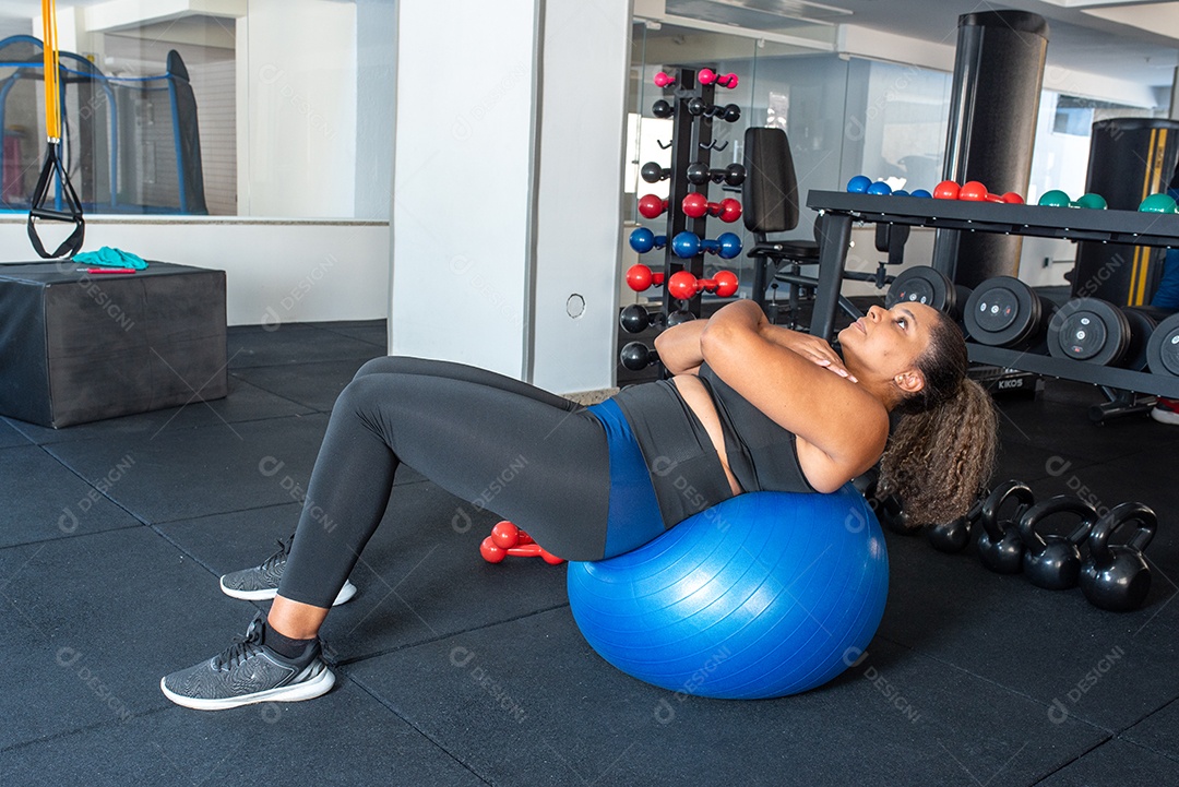 Mulher desportiva exercitando em multiestação na academia