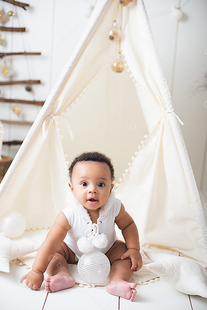 Um lindo bebê na toca de decoração natalina