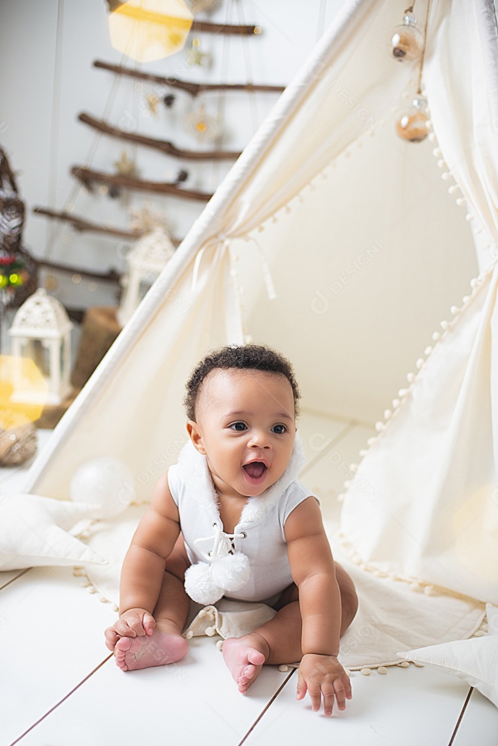 Um lindo bebê na toca de decoração natalina