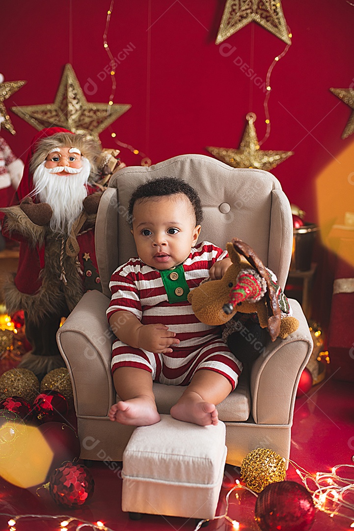 Um lindo bebê vestido a caráter para fotos natalina