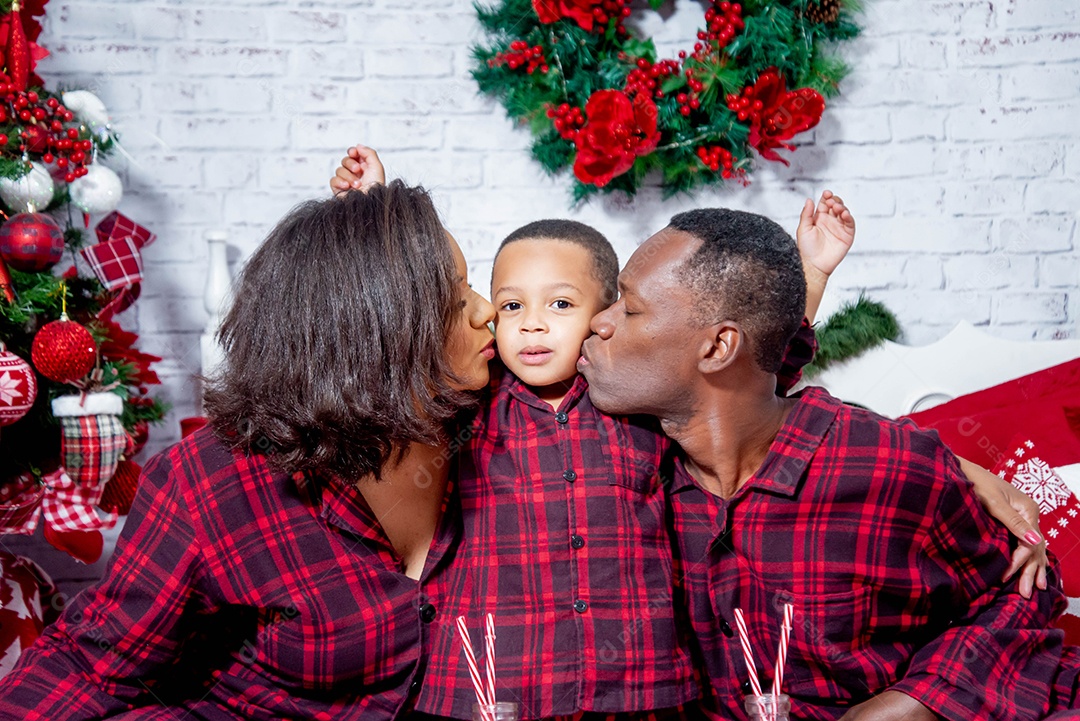 Pai e mãe beijando seu filho