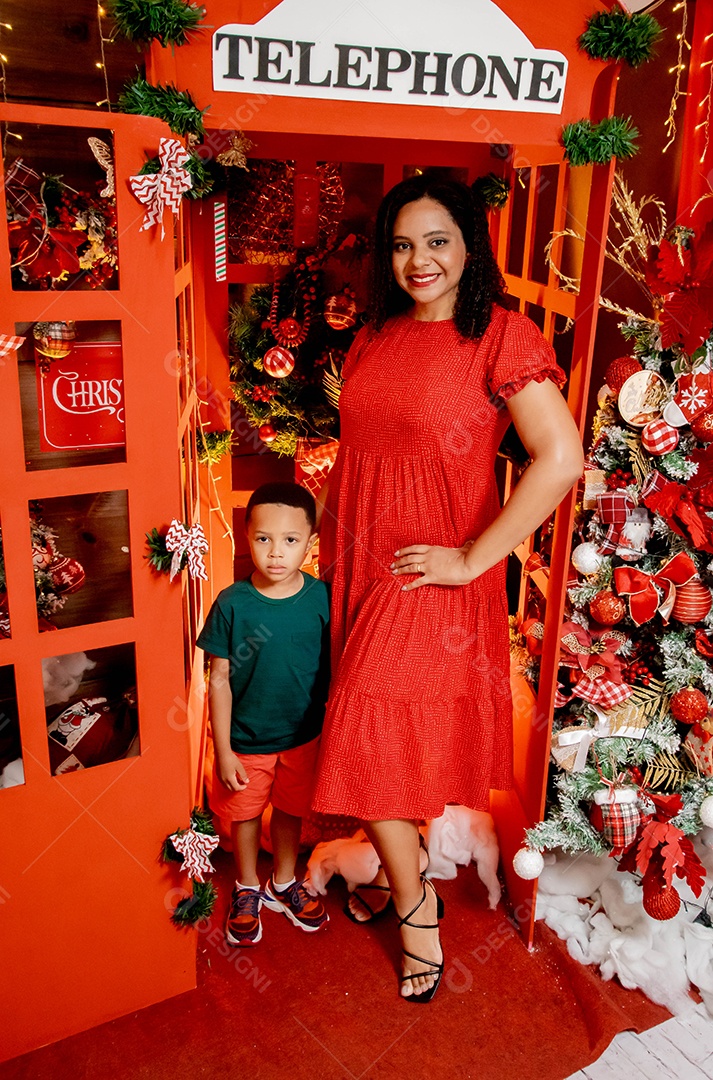 Uma mãe com seu filho tirando foto na decoração natalina