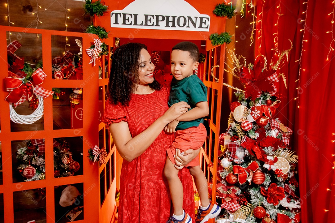 Mãe com seu filho no colo tirando foto natalina