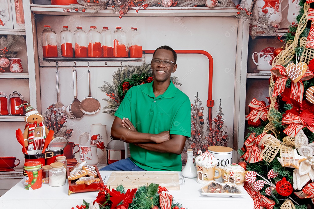 Um homem moreno sentado com uma linda decoração natalina