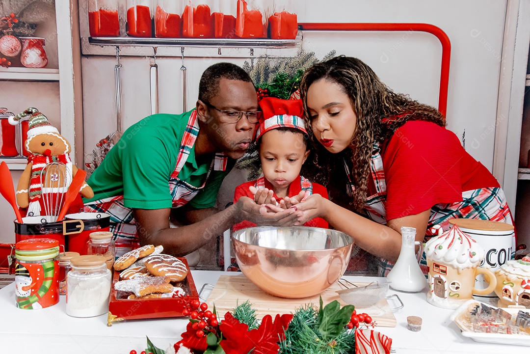 Uma linda família se divertindo na cozinha com bolos de natal