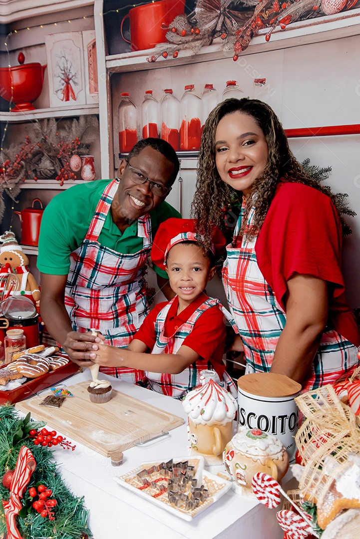 Um lindo casal com seu filho se divertindo na cozinha de natal