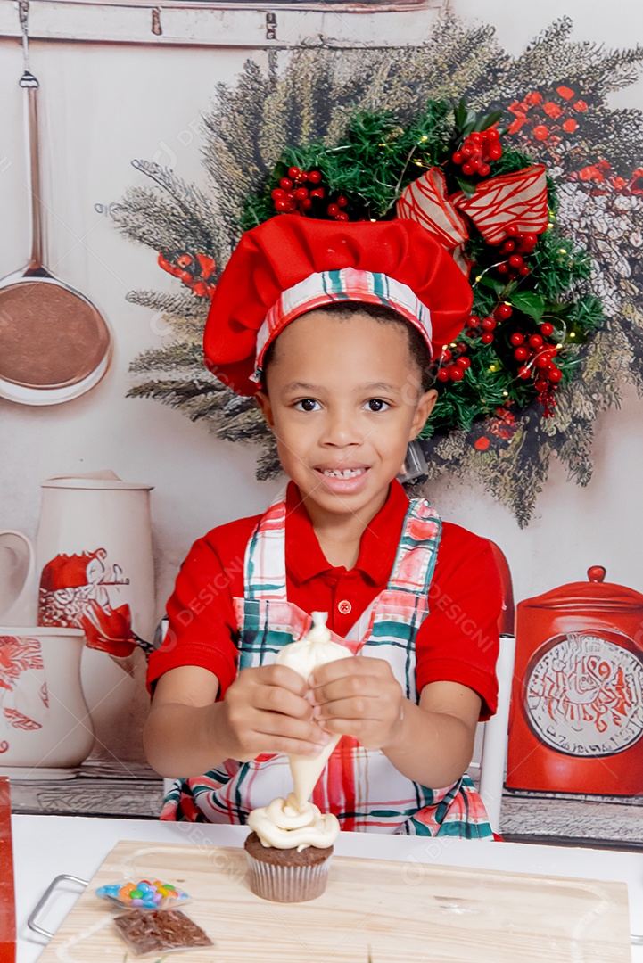 Um lindo garotinho vestido de chefe confeiteiro