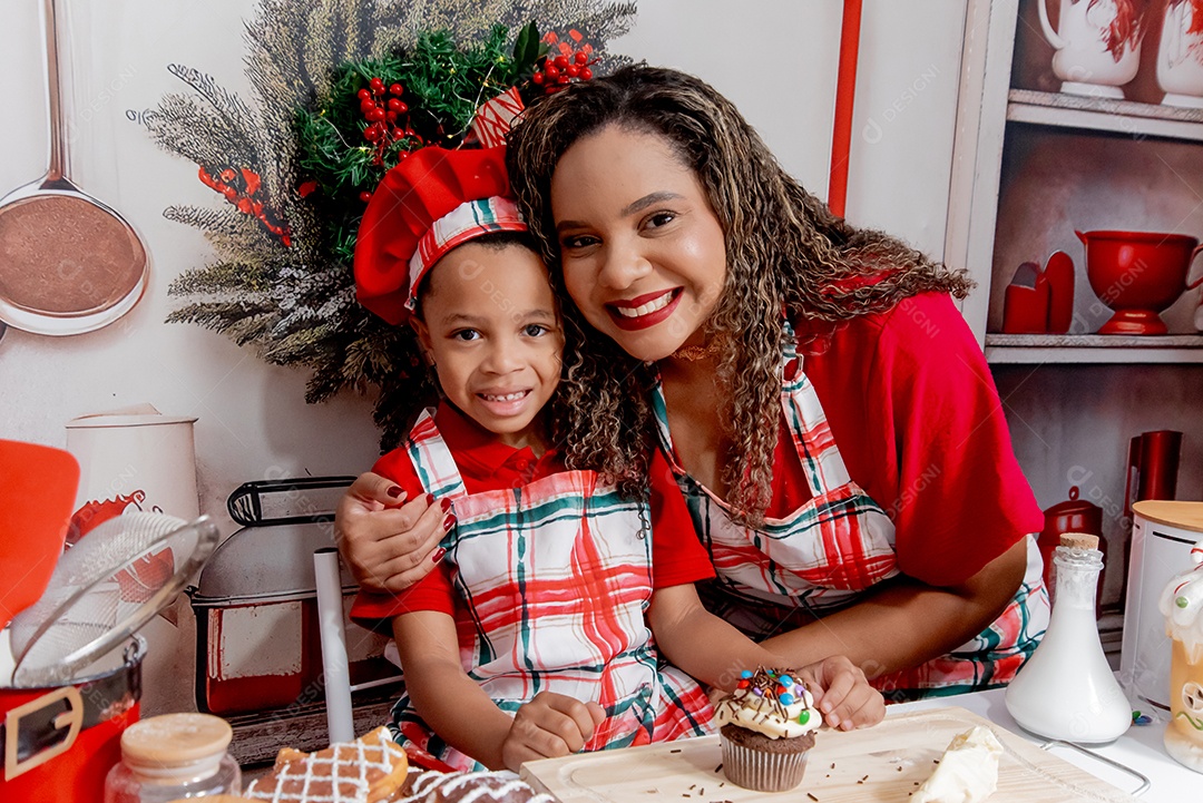 Mãe com seu filho juntos cozihando biscoitos natalinos