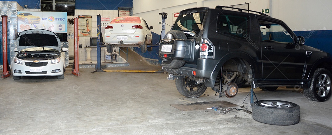 Carros em manutenção sobre oficina