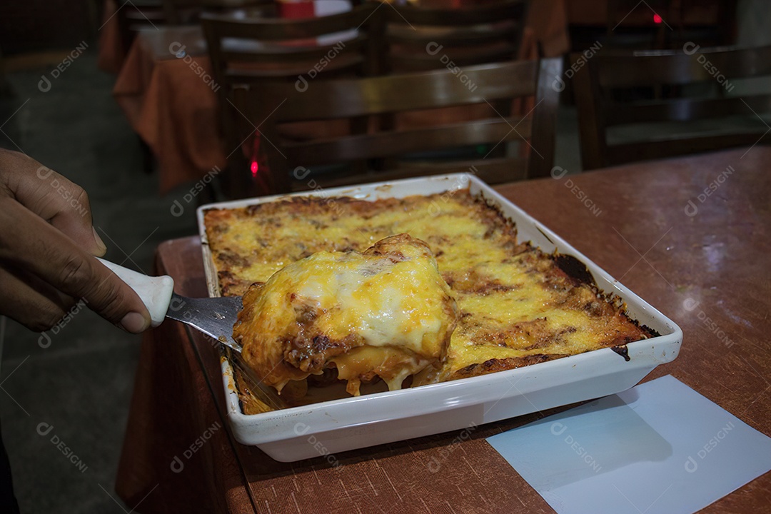 Linda lasanha encima de uma mesa de madeira sobre restaurante