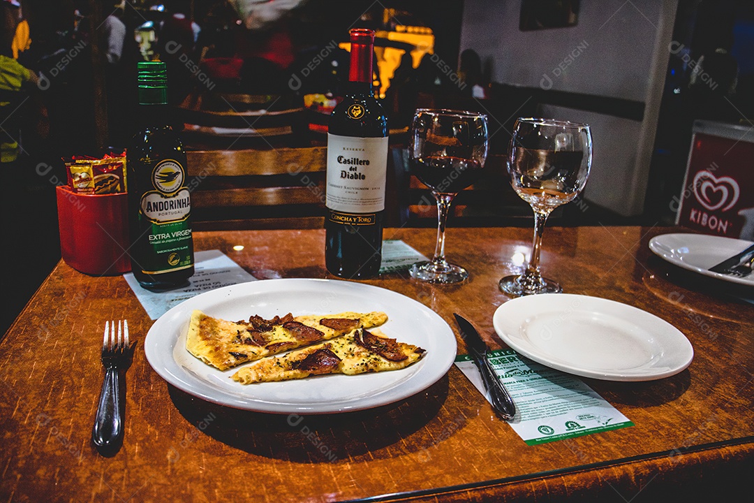 Comida com acompanhamentos em mesa de madeira sobre restaurante