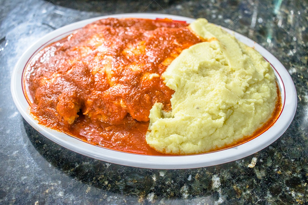 Delícioso filé de frango à parmegiana com purê de batata sobre mesa de pedra