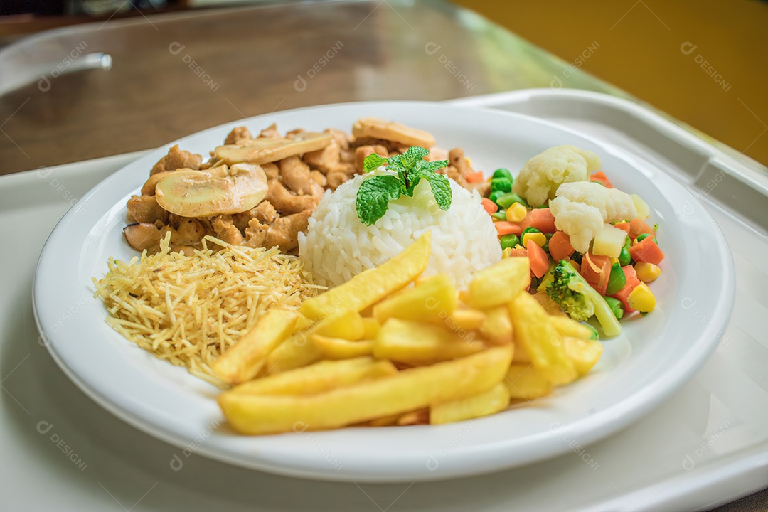Prato de comida brasileira com carnes arroz batata frita e macarrão sobre mesa de madeira