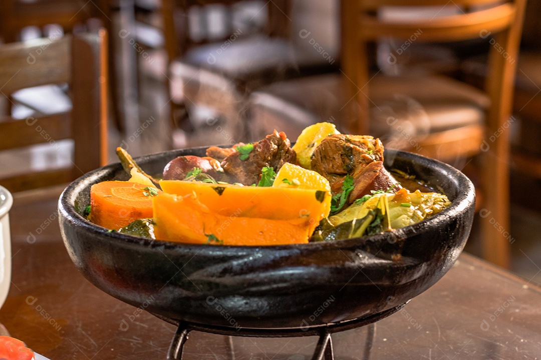 Carne na panela de Barro sobre mesa de madeira