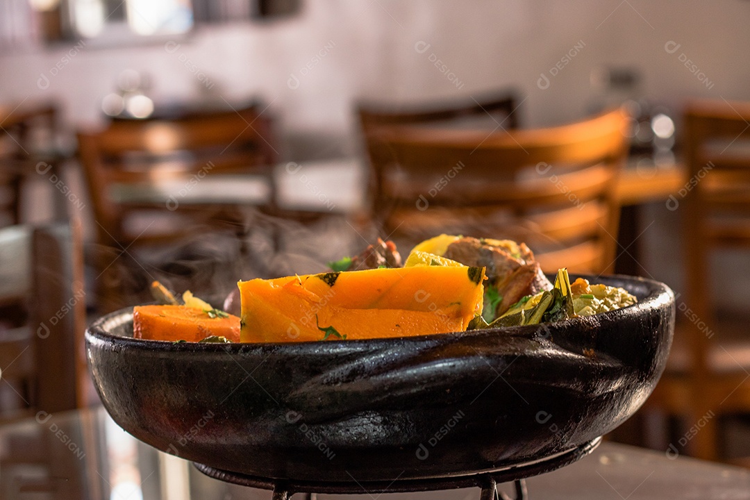 Carne na panela de Barro sobre mesa de madeira