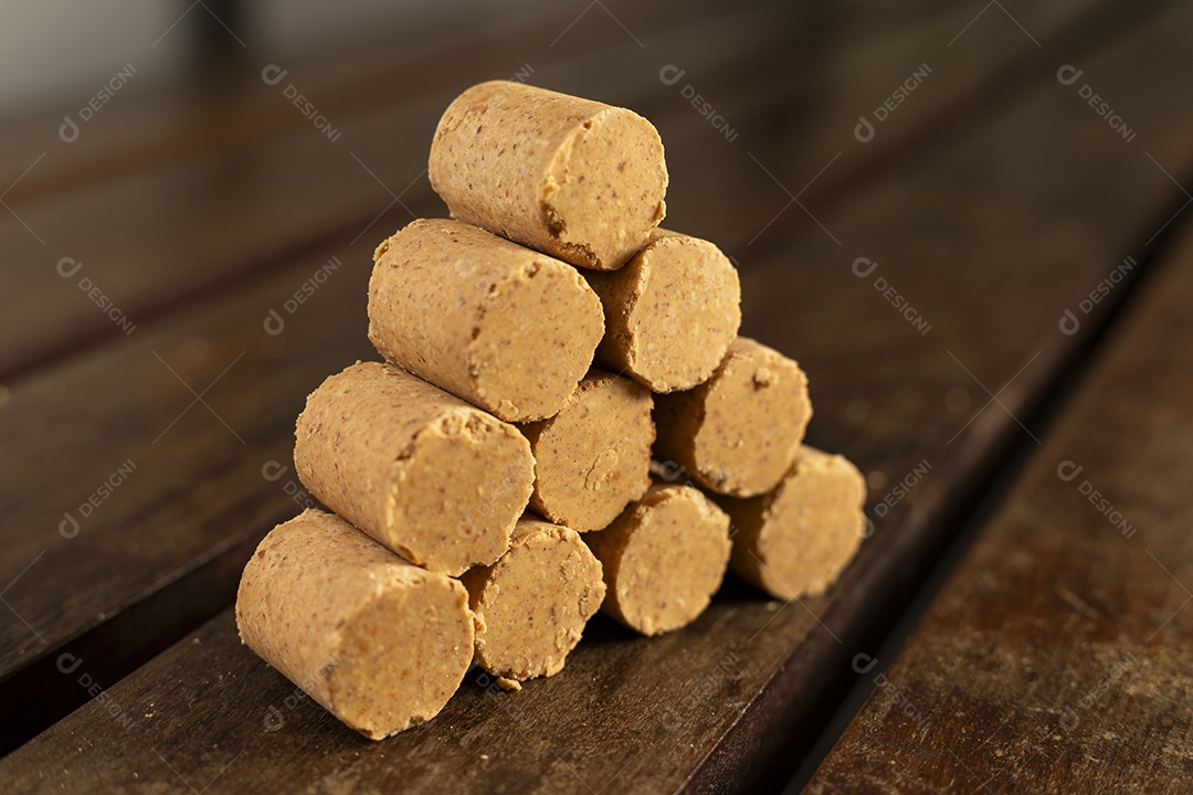 Paçocas de amendoim empilhadas sobre uma mesa de madeira