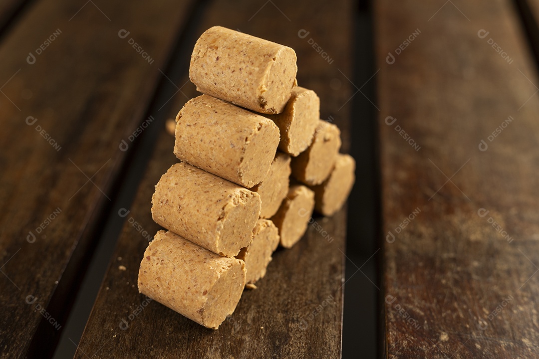 Paçocas de amendoim empilhadas sobre uma mesa de madeira